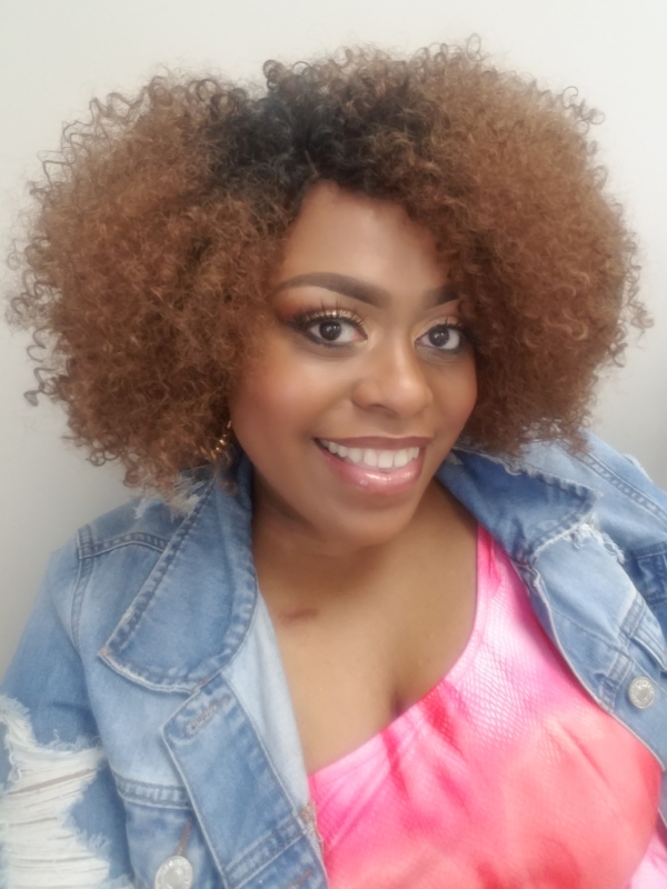 Woman smiling in a selfie with jean jacket and pink shirt