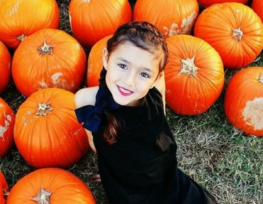 Girl in black in a pumpkin patch