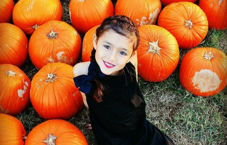 Girl in black in a pumpkin patch