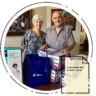An old couple standing with their CareBOX items laid out on the table
