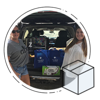 Two CareBOX employees at the trunk of the car showing items being delivered