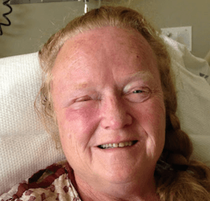 Woman smiling while laying down at the camera