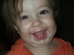 Toddler in orange shirt smiling
