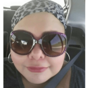 Woman in sunglasses and cheetah print bandana buckled into car