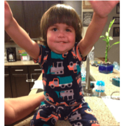 Kid in pajamas sitting on counter and reaching