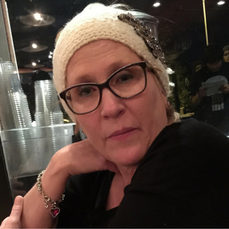 Woman in white beanie and black glasses