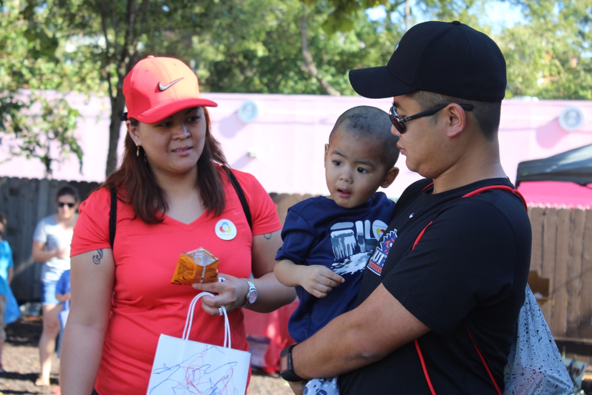 Woman in all red and man holding boy