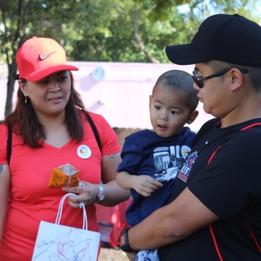 Woman in all red and man holding boy