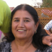 Lady with black hair and hoop earrings smiling at the camera