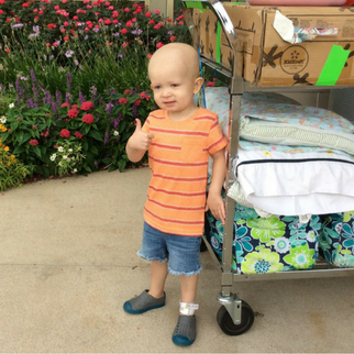 Boy in orange shirt with a thumbs up