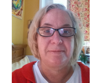 Woman in white shirt and red cardigan with glasses