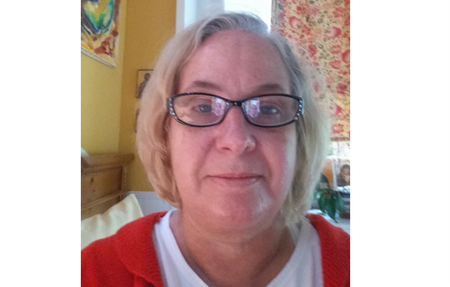 Woman in white shirt and red cardigan with glasses