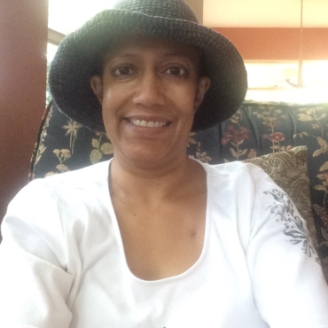 Woman in white shirt and green sewn hat selfie