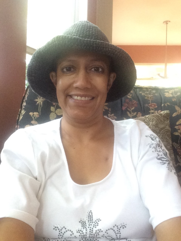 Woman in white shirt and green sewn hat selfie
