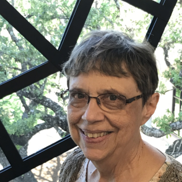 Woman with short hair and glasses smiling