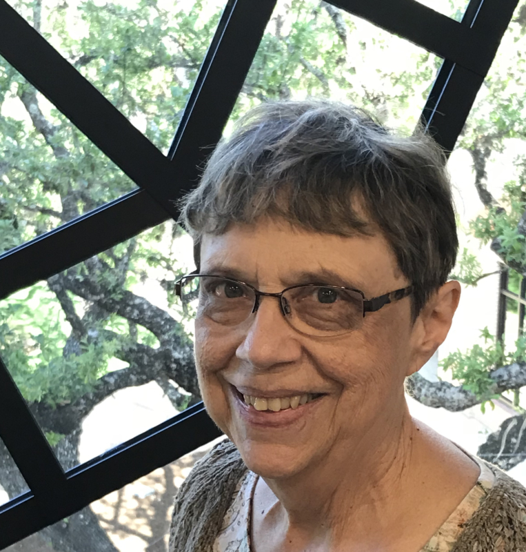 Woman with short hair and glasses smiling